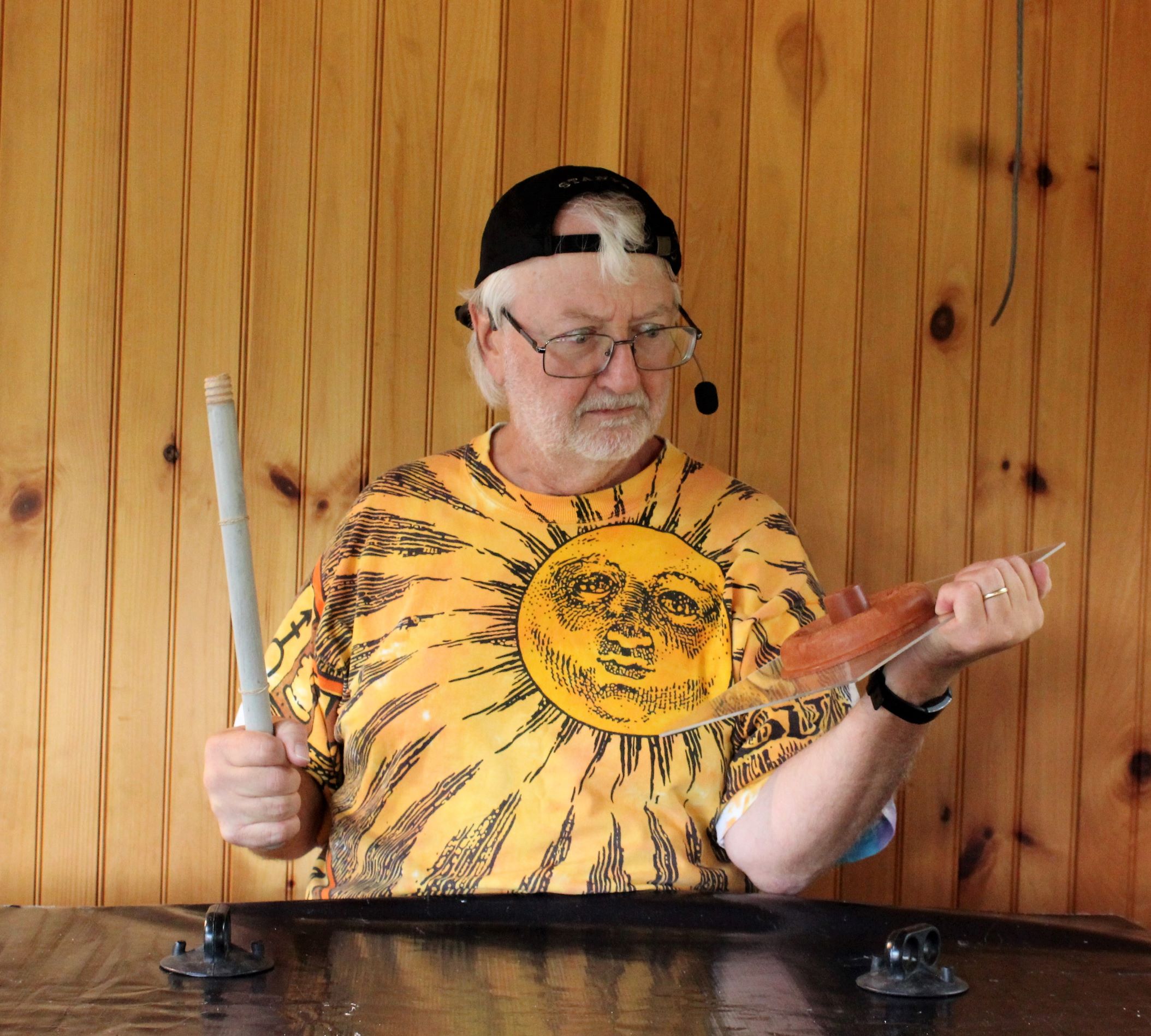 The Dirtmeister holding a toilet plunger with the suction cup stuck to a piece of plastic and the handle broken off in his hand.